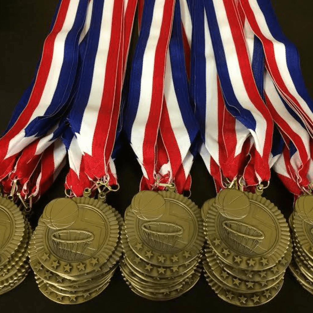 Gold medals with blue, white, and red strap laid in a black table